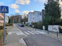 Neuer Fußgängerüberweg Im Birkenfeld in Form eines Zebrastreifens mit einem breiteren Gehweg zu beiden Seiten sowie Leitelementen am Boden.