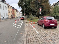 Neue Straßenmarkierungen und Pfosten als Gehwegverlängerung an einer unübersichtlichen Kreuzung.