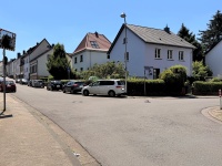 Parkende Autos an einer engen Kreuzungseinfahrt, die die Sicht einschränken.