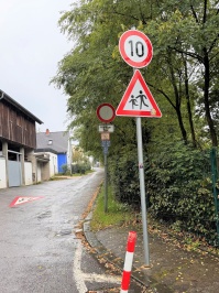 Ein Verkehrsschild weist sowohl auf eine Höchstgeschwindigkeit von 10 km/h als auch auf Kinder hin.