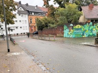 Fußgänger-Piktogramme auf beiden Gehwegseiten weisen auf eine Querungsstelle hin.