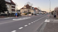 Eine neue Verkehrsinsel inmitten einer breiten Straße inklusive Leitelementen am Gehweg  sowie neue Radfahrstreifen.
