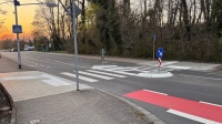 Eine neue Verkehrsinsel inmitten einer Straße inklusive Leitelementen am Gehweg sowie ein neuer Radahrstreifen.